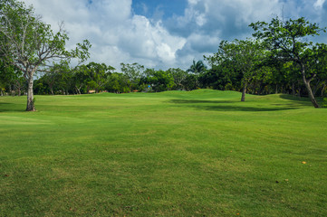 Naklejka na ściany i meble Golf course in Dominican republic. field of grass and coconut