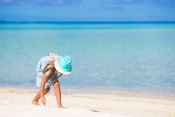 Fototapeta na wymiar Adorable happy smiling little girl in hat on beach vacation