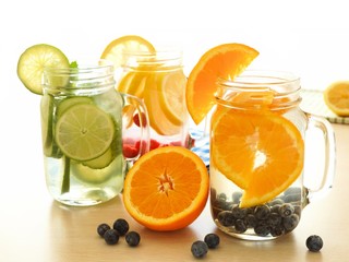 Detox water with various types of fruit in mason jars on a table