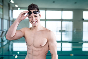 Fototapeta na wymiar Young muscular swimmer with protective glasses