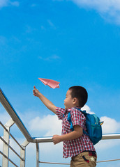 Asian Boy 5 years old, under the blue sky happily playing with paper plane,