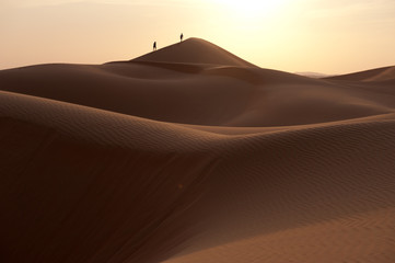 Fototapeta na wymiar People walking in a dune's desert