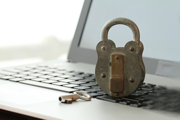 Internet security concept-old padlock and key on laptop computer
