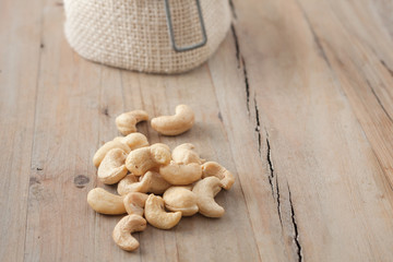 small pile of raw cashew nuts on wooden background