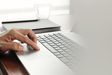 Close up of business man working on laptop computer on wooden de