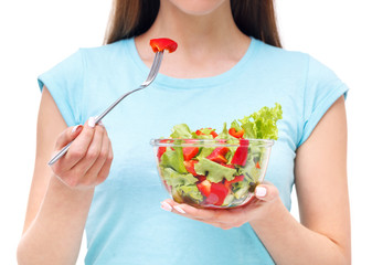 Portrait of a fit healthy woman eating a fresh salad isolated on