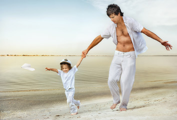 Happy father and son playing at the beach