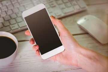Woman using her smartphone and keyboard