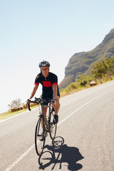 Naklejka premium Male cyclist riding down a country road