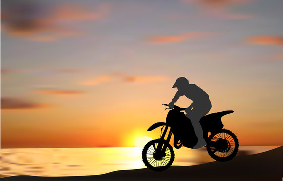 man on motorcycle near sea at sunset