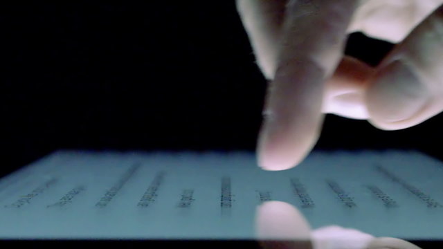 Touching Tablet Touch screen at dark, close up