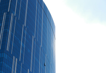 Fototapeta na wymiar Glass facade of an urban building reflecting clouds