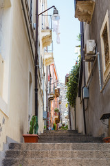 Fototapeta na wymiar steps on narrow street in Catania city, Sicily