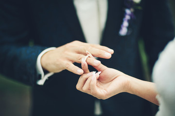 Obraz na płótnie Canvas Bride and groom exchanging wedding rings