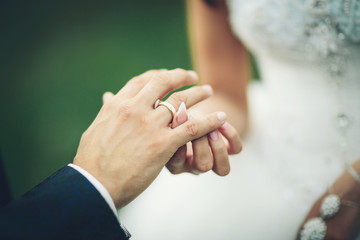 Bride and groom exchanging wedding rings