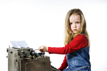 Plakat Cute little girl typing on vintage typewriter keyboard