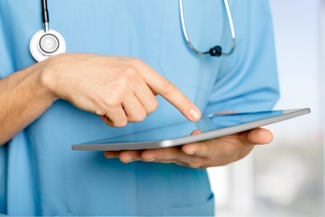 Tablet. Hands of doctor using tablet computer