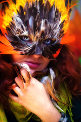 Young woman with a colorful feather carnival face mask eye 