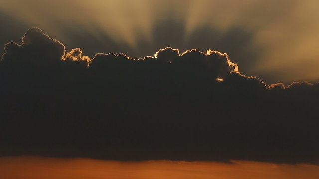 fantastic view of sun rays from clouds at sunset above sea	