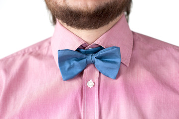 Blue bow-tie with pink shirt on men's neck.
