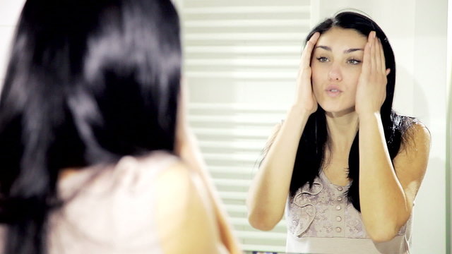 Woman talking to herself getting angry in front of mirror