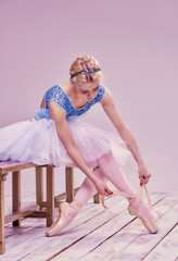 Professional ballerina putting on her ballet shoes.