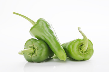 fresh green chilies on white background display