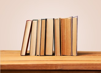 Book. Vintage books on wooden table over retro wallpaper
