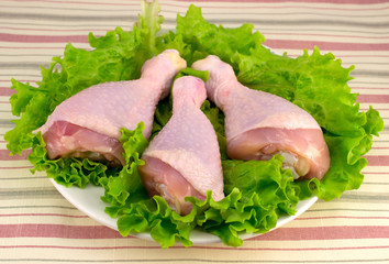 chicken legs on the plate with a green tablecloth on