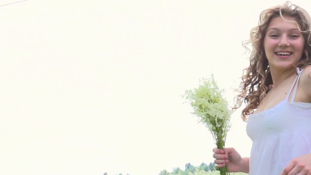 Beauty girl with bunch of wild flowers outdoor. Full HD. Slow-mo
