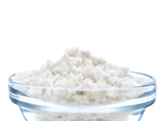 Sea salt in glass bowl close-up isolated on white