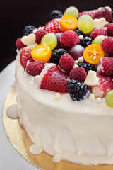 White chocolate cake decorated with fresh berries and fruits