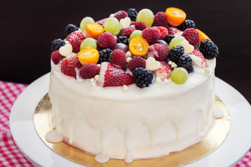 White chocolate cake decorated with fresh berries and fruits