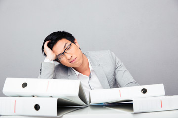 Fototapeta premium Tired young businessman sitting at the table