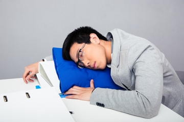 Fototapeta premium Young businessman sleepig on the table