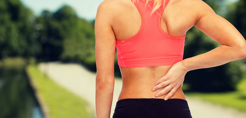 close up of sporty woman touching her back