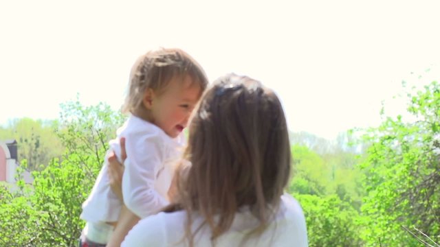 Mother and baby having fun in spring park. Slow motion 240 fps