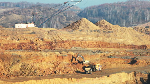 excavator loading huge dump trucks