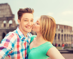 Naklejka premium couple kissing and taking selfie over coliseum