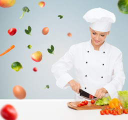 smiling female chef chopping vegetables