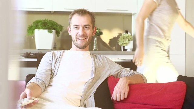 Young Couple Watching TV on the Sofa in the Living Room