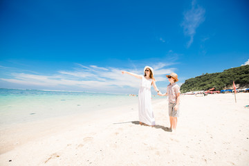 Happy beautiful young mother and son enjoying beach time with