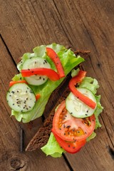 Rye sandwich with salad leaves, tomato, cucumber, bell pepper on