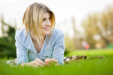 Fototapeta premium portrait of a beautiful woman sitting in grass