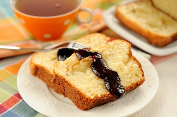 Mascarpone cake slice, cup of tea in orange teacup, blueberry ja