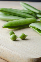 Pea Pods and Peas on Chopping Board