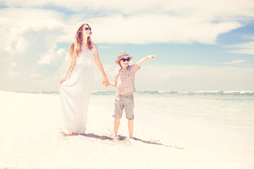 Happy beautiful mother and son enjoying beach time