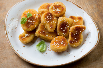 Sesame chicken nuggets on a plate, close-up, studio shot