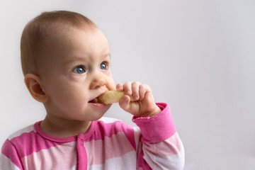 adorable baby girl  eating  a crunchy corn snack