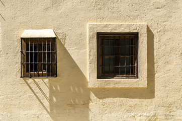 vergitterte Fenster in historischer Mauer